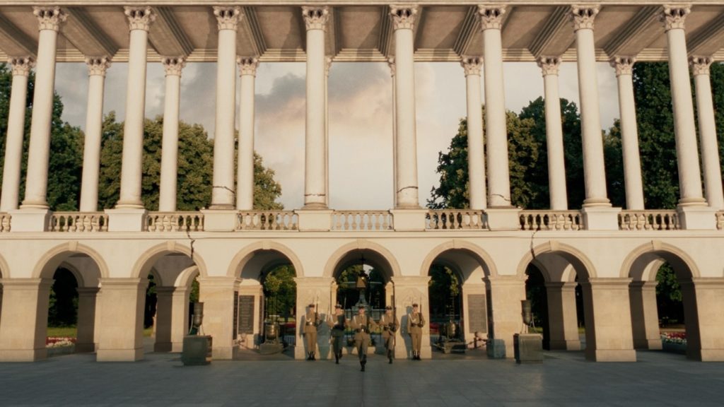 Wizualizacja kolumnady Pałacu Saskiego od strony placu Piłsudskiego. Na środku, pod arkadami, znajduje się Grób Nieznanego Żołnierza, przy którym odbywa się zmiana warty wojskowych. W tle kolumn roślinność Ogrodu Saskiego.