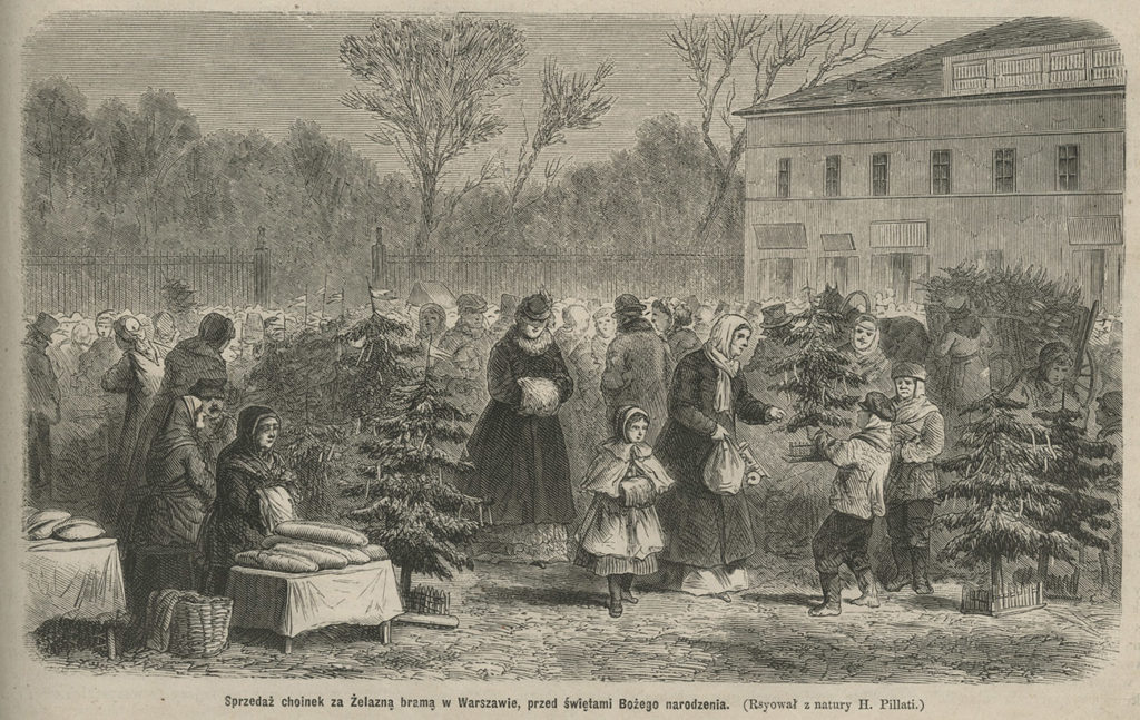 Na pierwszym planie kobiety i dzieci. Odbywa się sprzedaż świątecznych choinek, chleba i ryb. W tle za kilkoma choinkami tłum ludzi, dalej ogrodzenie i drzewa, po prawej stronie piętrowy budynek.