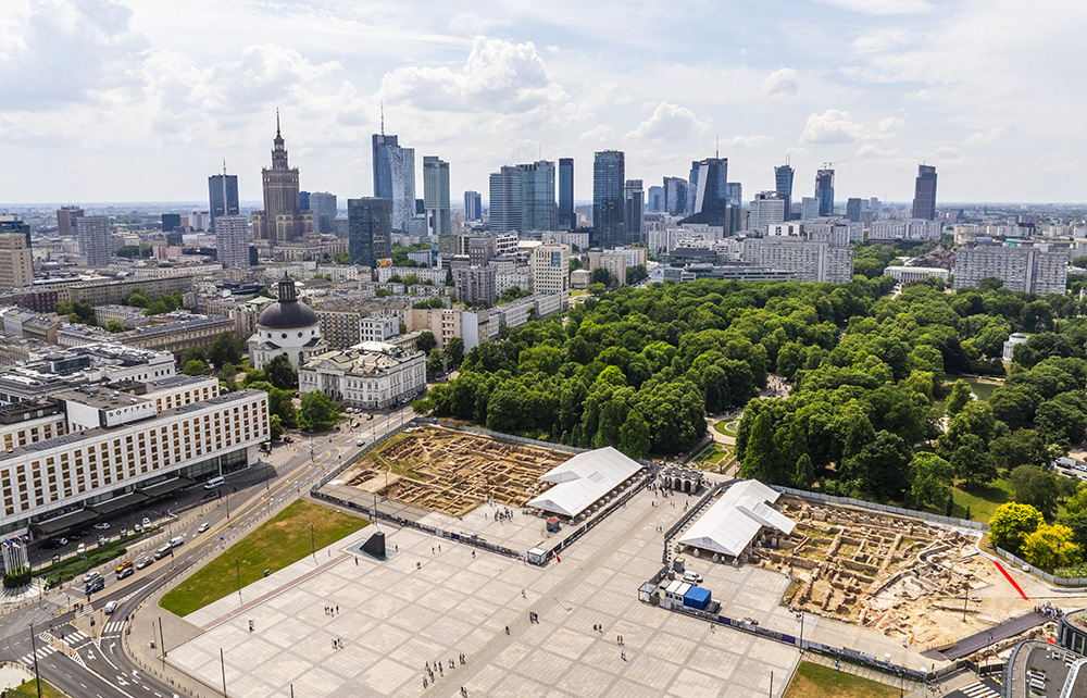 Historia odbudowy Pałacu Saskiego: widok z lotu ptaka na odsłonięte Pałacu Saskiego przy placu Piłsudskiego w Warszawie. W tle Ogród Saski, a za nim panorama wieżowców.