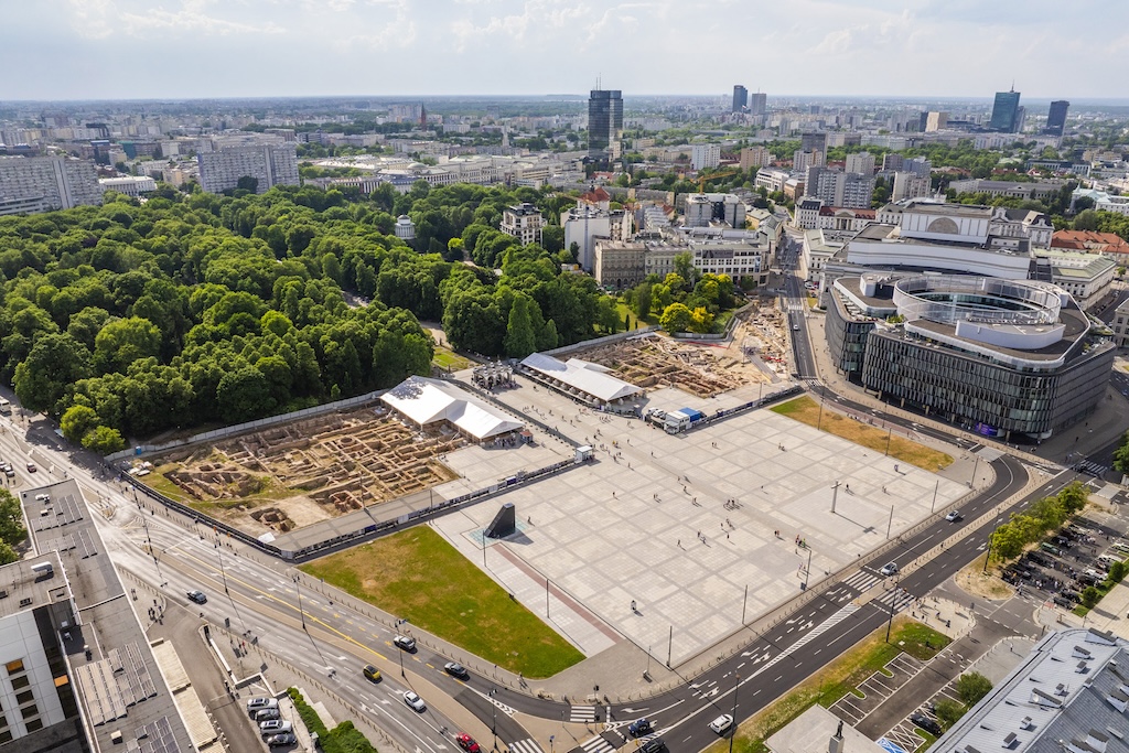 Widok z lotu ptaka na plac Piłsudskiego, którego część granicząca z Ogrodem Saskim jest wydzielona ogrodzeniem. Wewnątrz ogrodzonego terenu rysują się fundamenty Pałaców Saskiego i Bruhla.